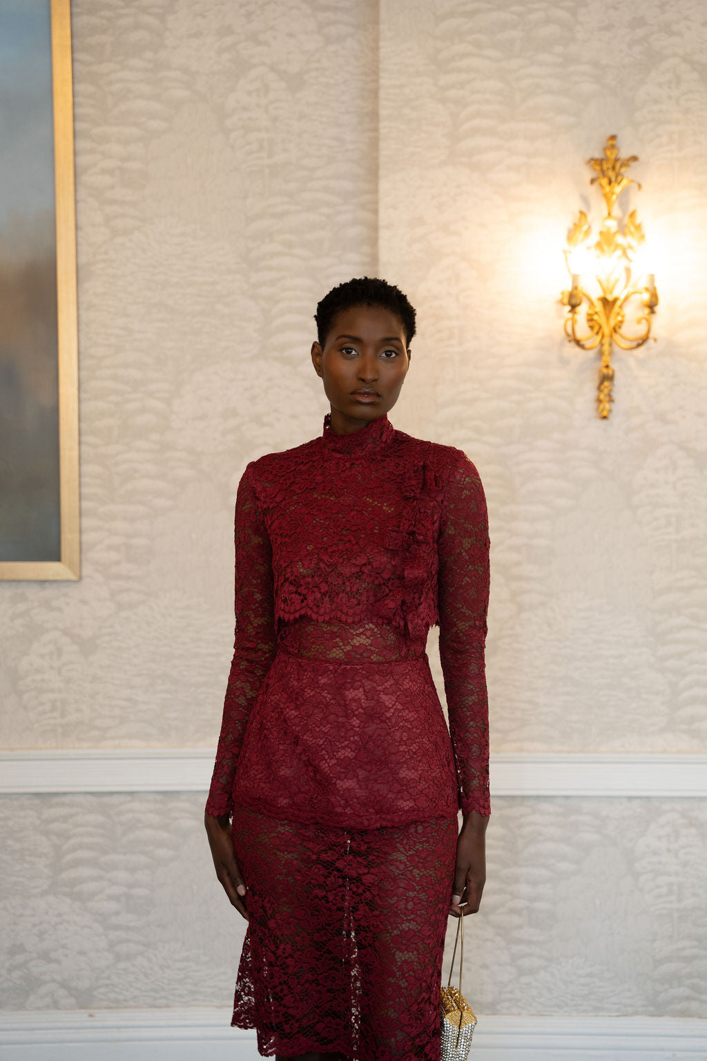 Burgundy lace midi dress with high neckline, long sleeves, and fitted waist detail.