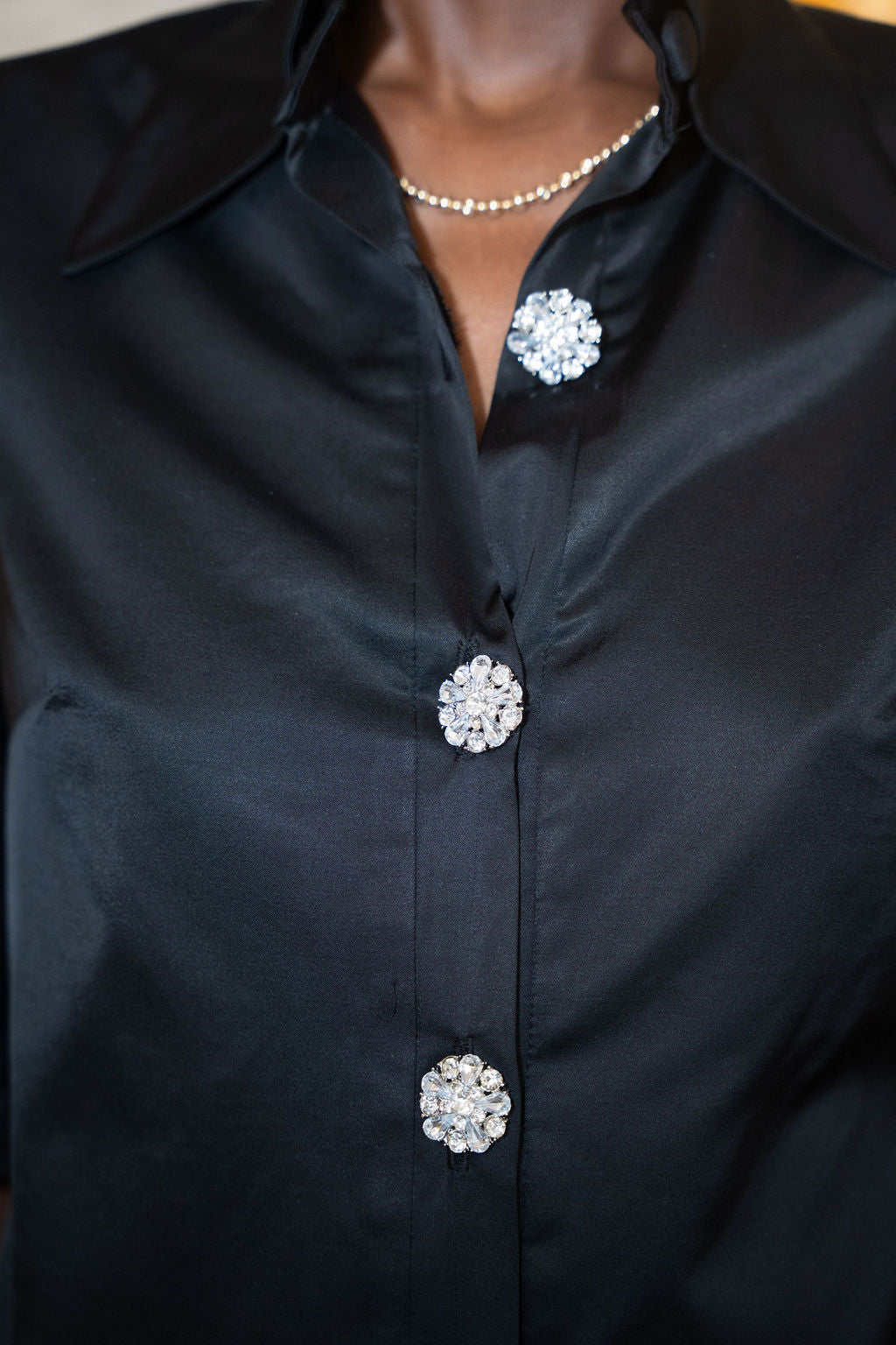 Black satin dress with velvet collar and three decorative crystal buttons.