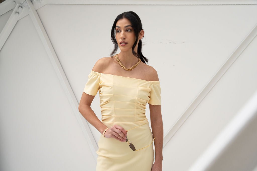 Light yellow off-the-shoulder midi dress with short sleeves and ruched detailing.