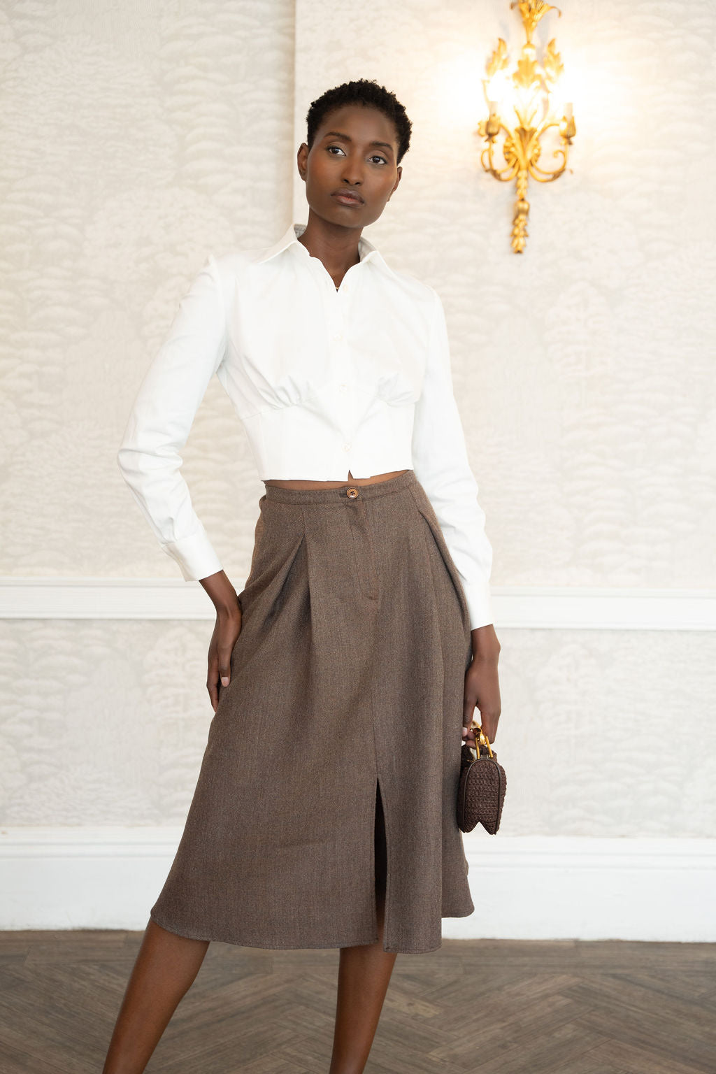 Ivory long-sleeve cotton corset shirt with front seam details and a cropped fit.