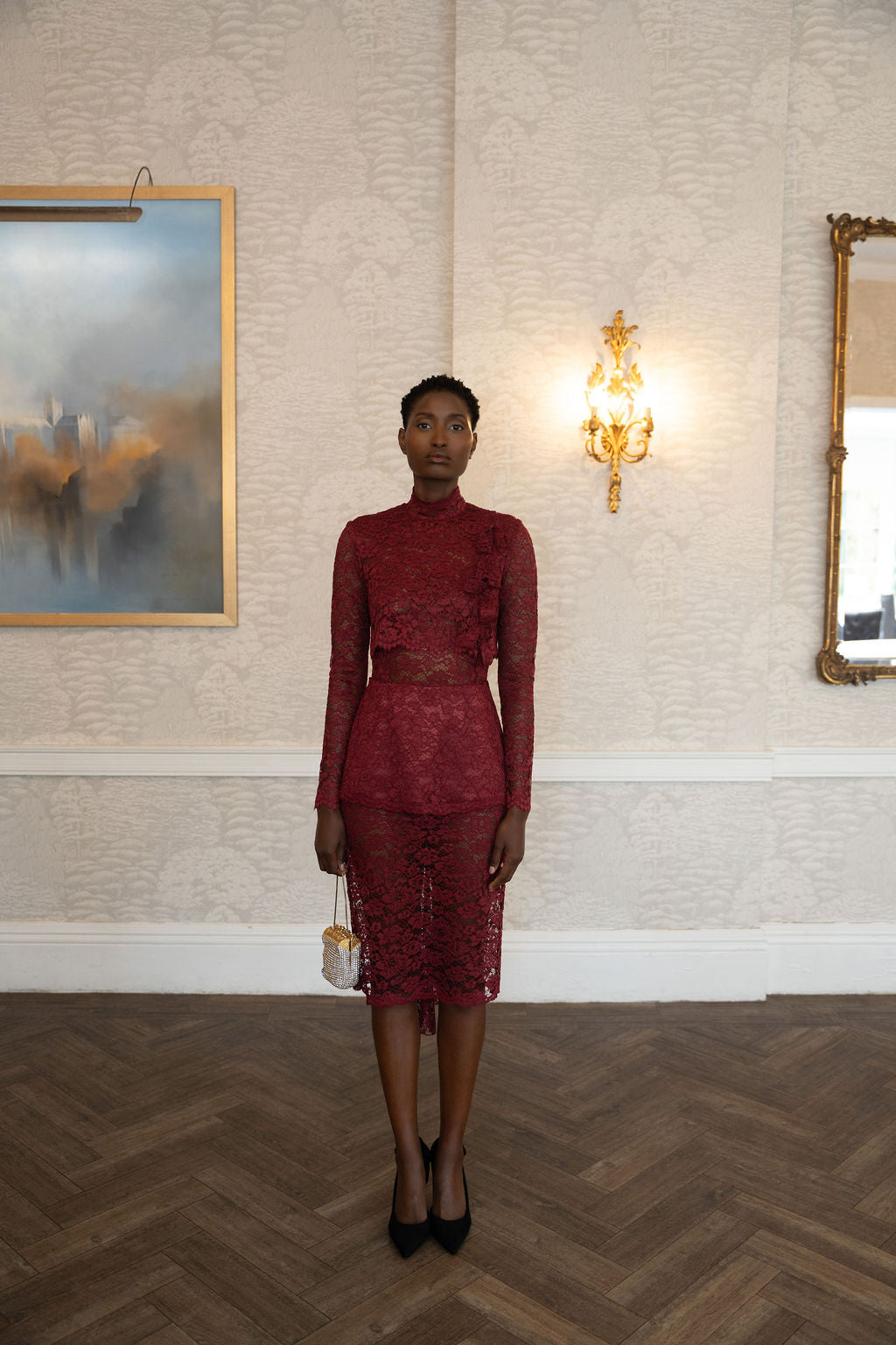 Burgundy lace midi dress with long sleeves and fitted waist, styled with black heels.