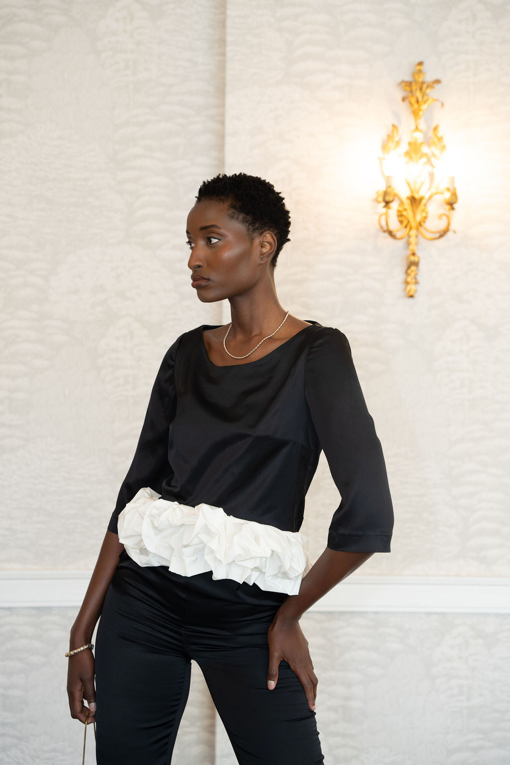 Black satin top with three-quarter sleeves and gathered white cloud-like waist detail.