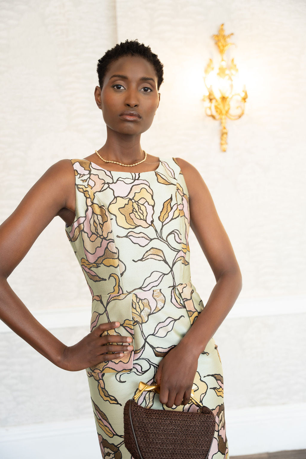 Sleeveless floral brocade midi dress with pastel pink and yellow roses on a light background.