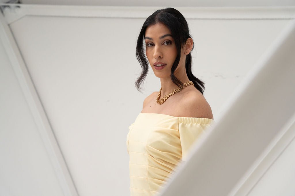 Light yellow off-the-shoulder midi dress with ruched bodice and short sleeves.